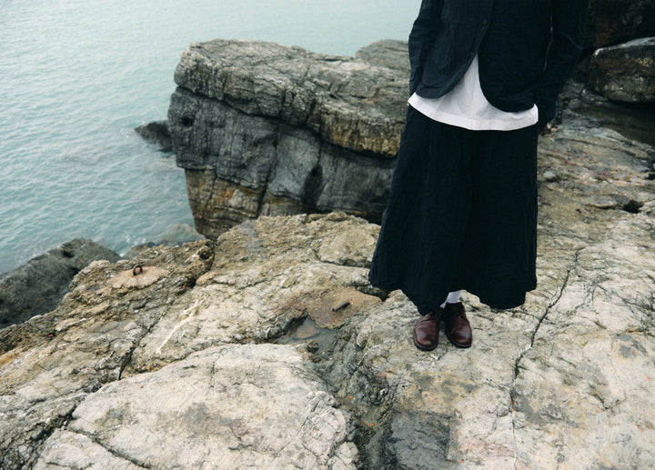 Person standing on rocky cliffs overlooking water