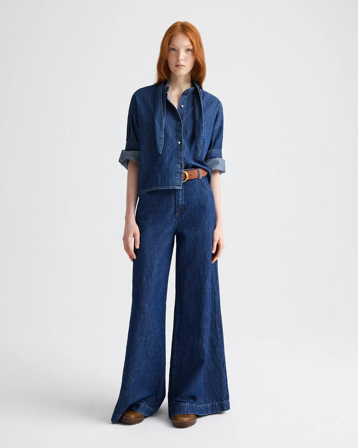 Woman wearing a blue denim outfit on a white background