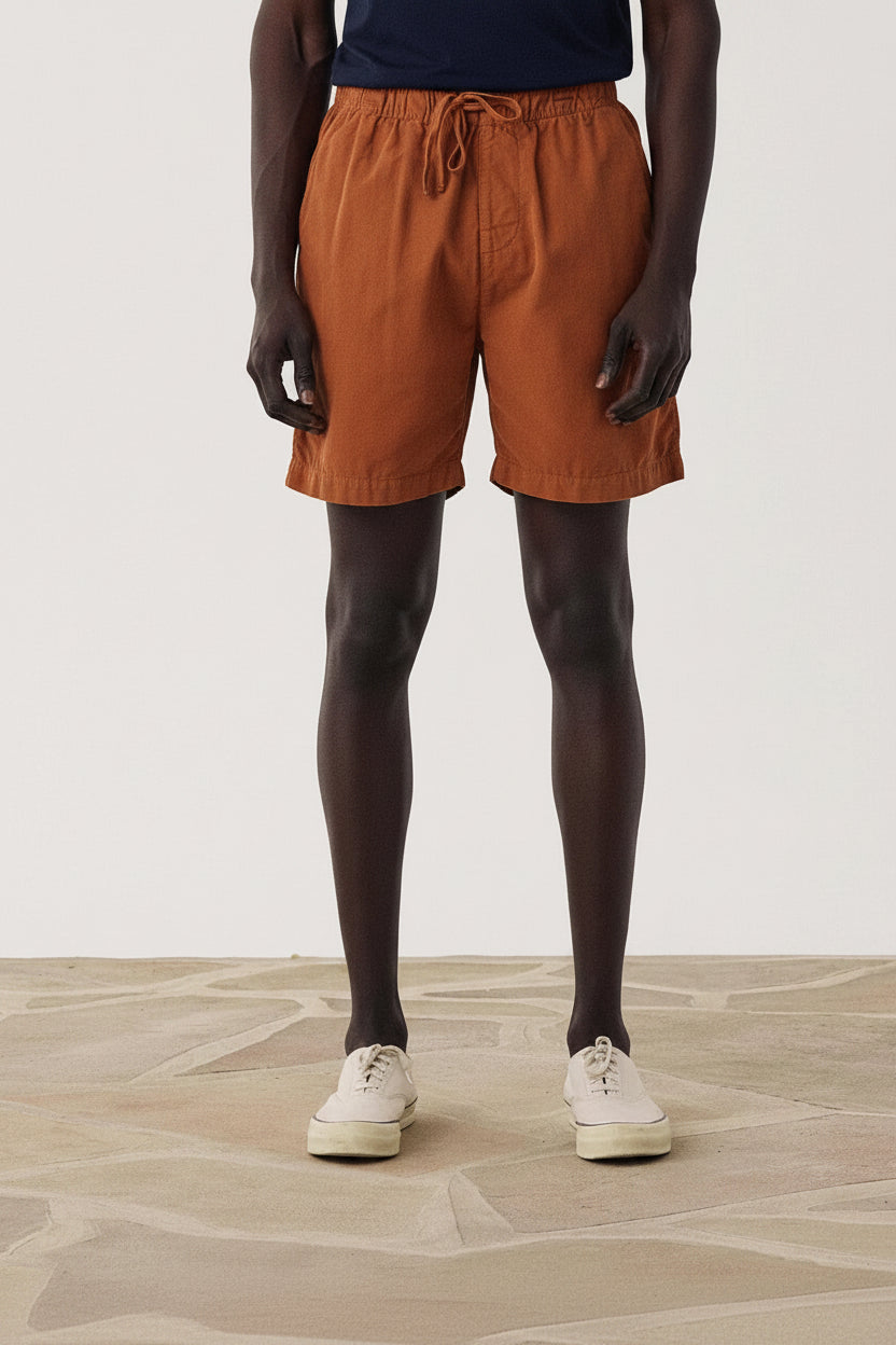 Person wearing blue shorts on a plain background
