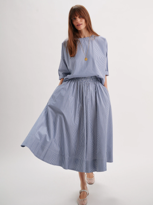 Woman wearing a blue striped dress on a white background