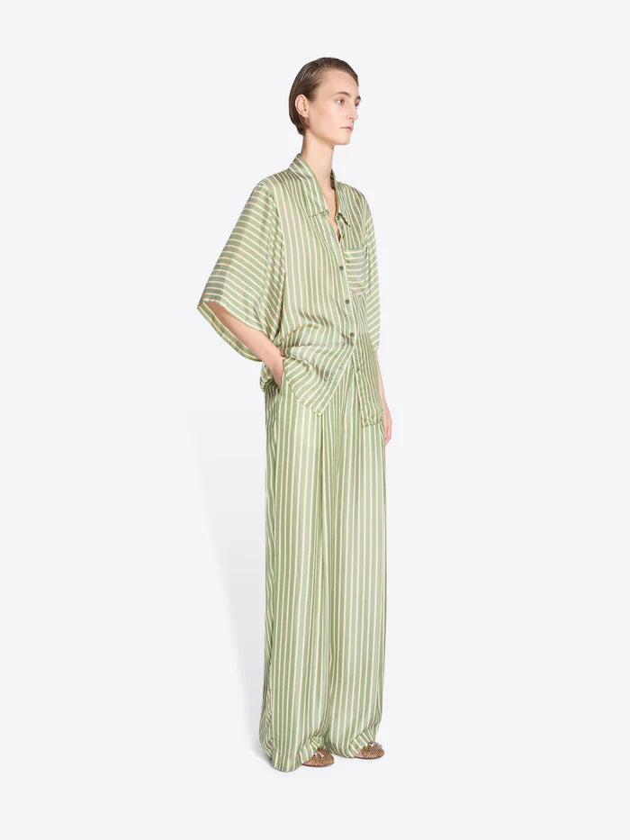 Woman wearing a green and white striped outfit on a white background