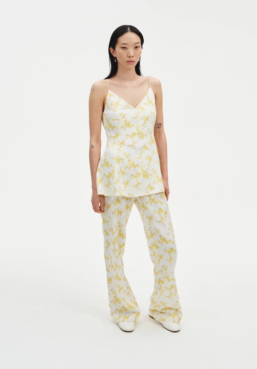Woman wearing a yellow floral pajama set on a white background
