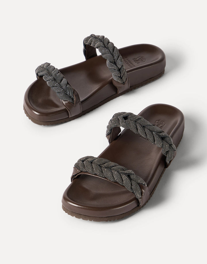 Pair of brown sandals with braided straps on a white background