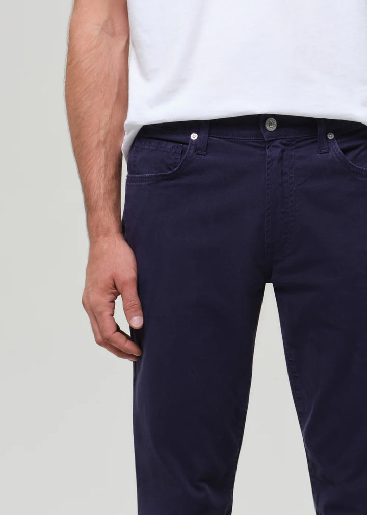 Navy blue pants worn by a person on a light gray background