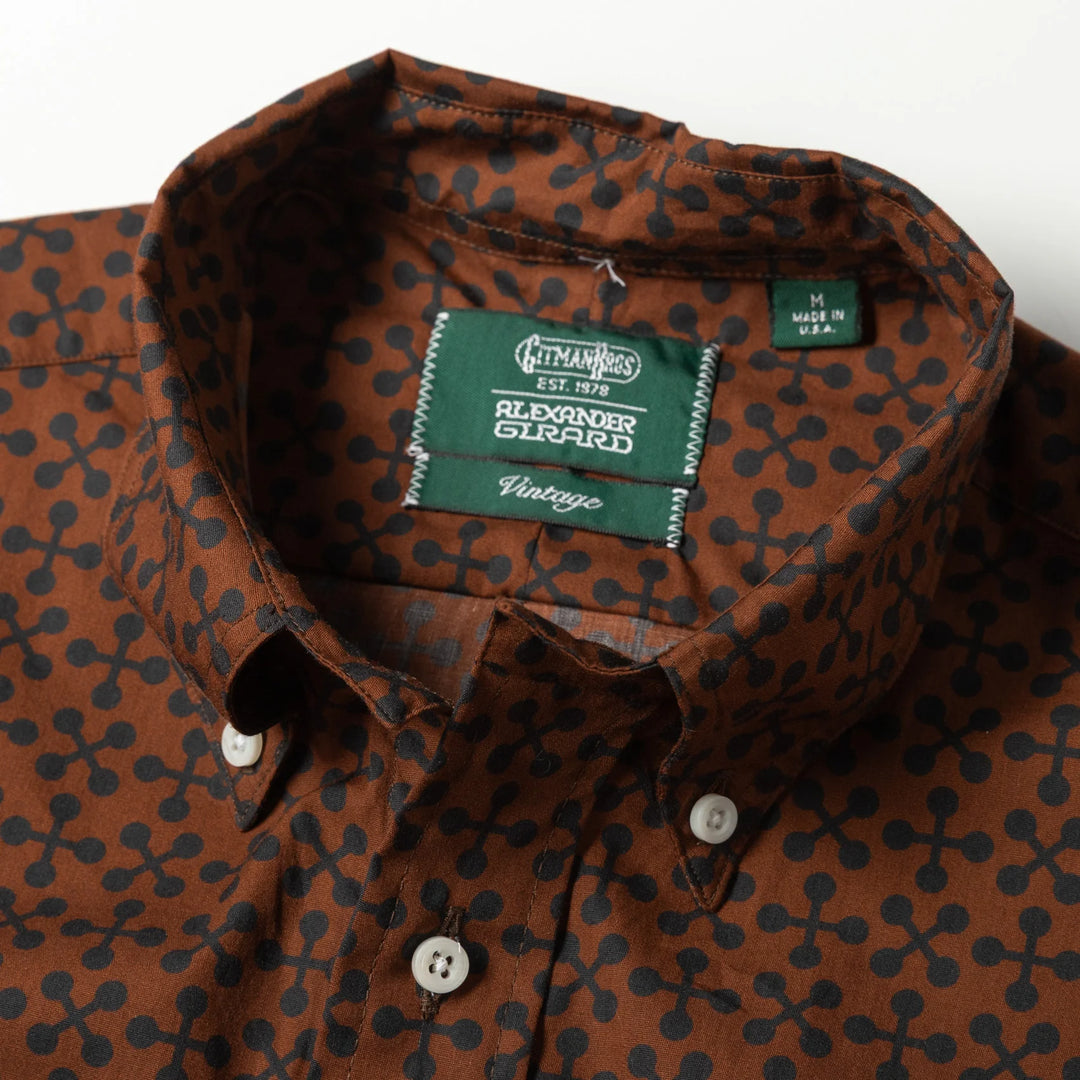 Brown patterned shirt with a brand label on a white background