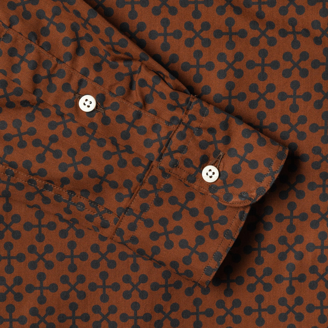 Brown fabric with black geometric pattern and white buttons