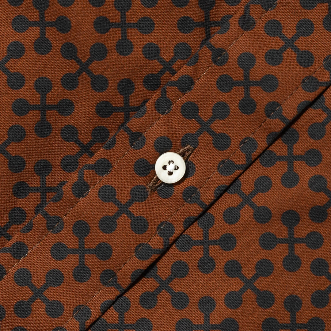 Brown fabric with black geometric pattern and a button