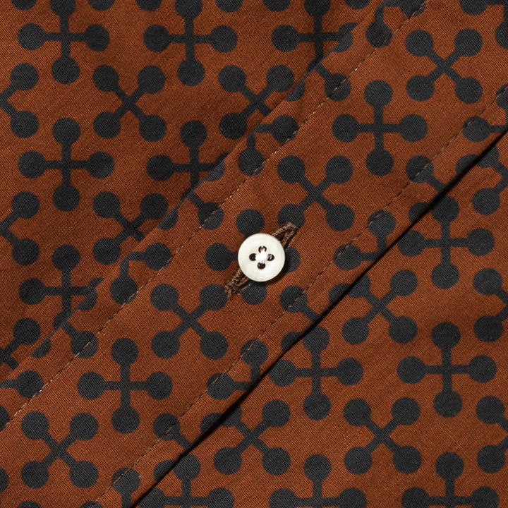 Brown fabric with black geometric pattern and a button