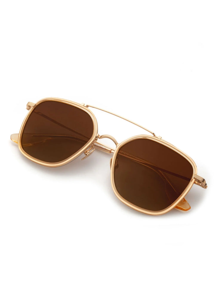 Gold-framed sunglasses with brown lenses on a white background