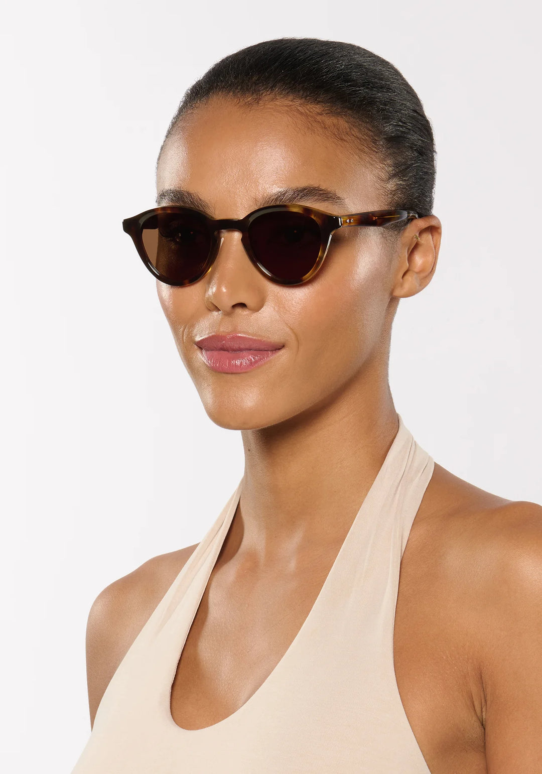 Woman wearing sunglasses with a plain background
