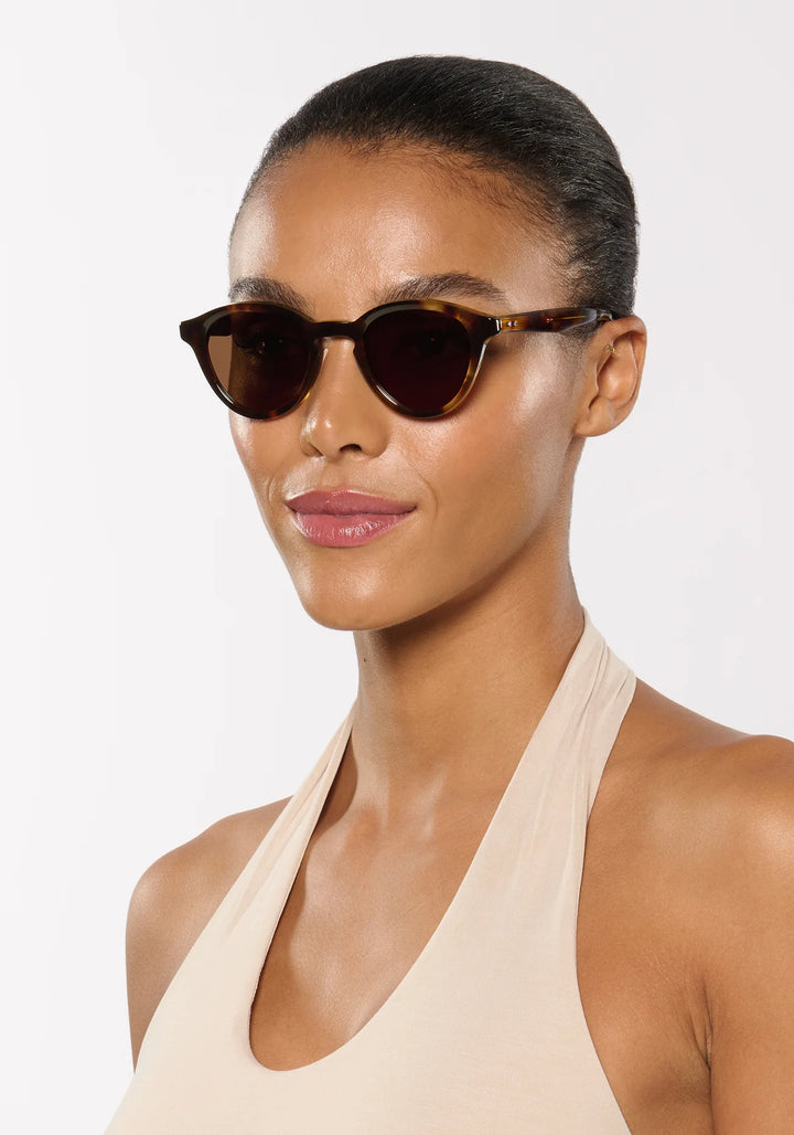 Woman wearing sunglasses with a plain background