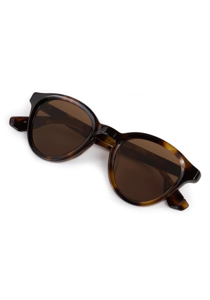 Sunglasses with tortoiseshell frame and brown lenses on a white background