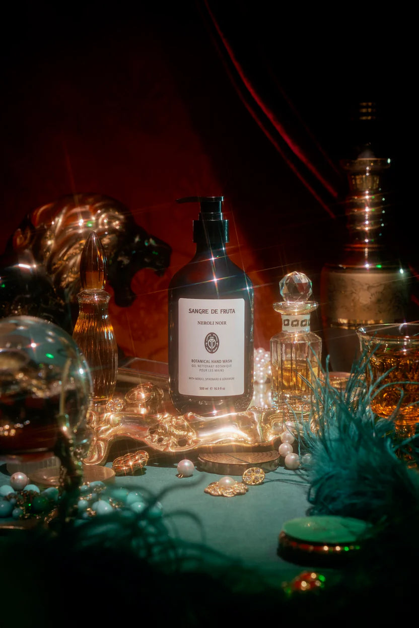 Bottle of L'Occitane Almond Body Lotion on a table with decorative items
