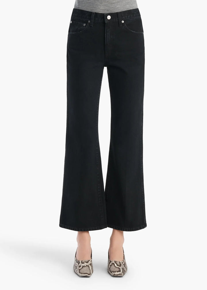 Black wide-leg jeans worn by a person on a white background