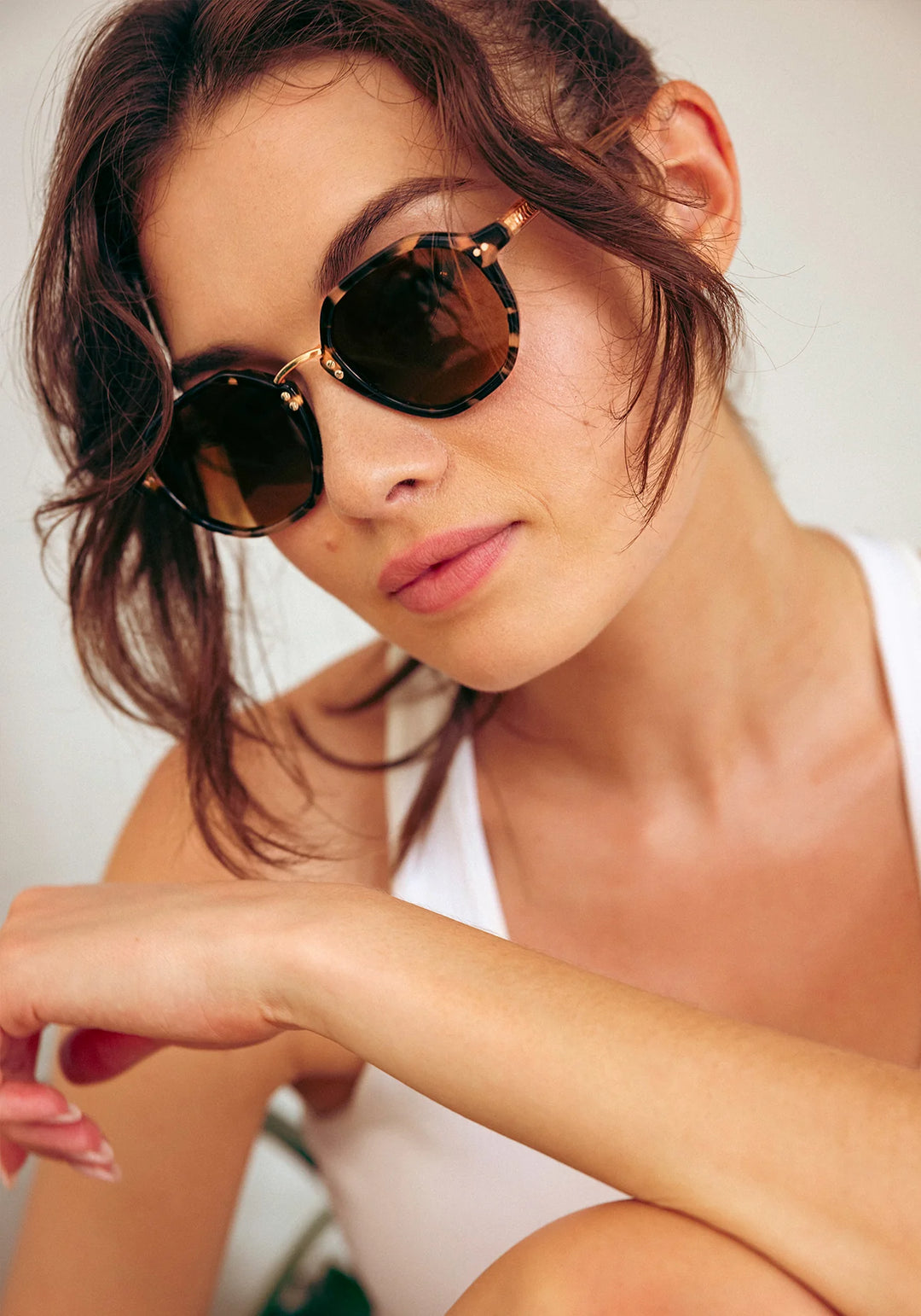 Woman wearing sunglasses with a neutral background