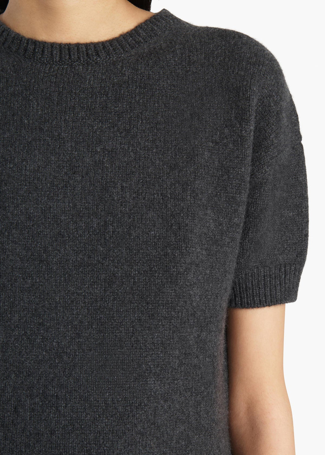 Dark gray sweater with short sleeves on a neutral background