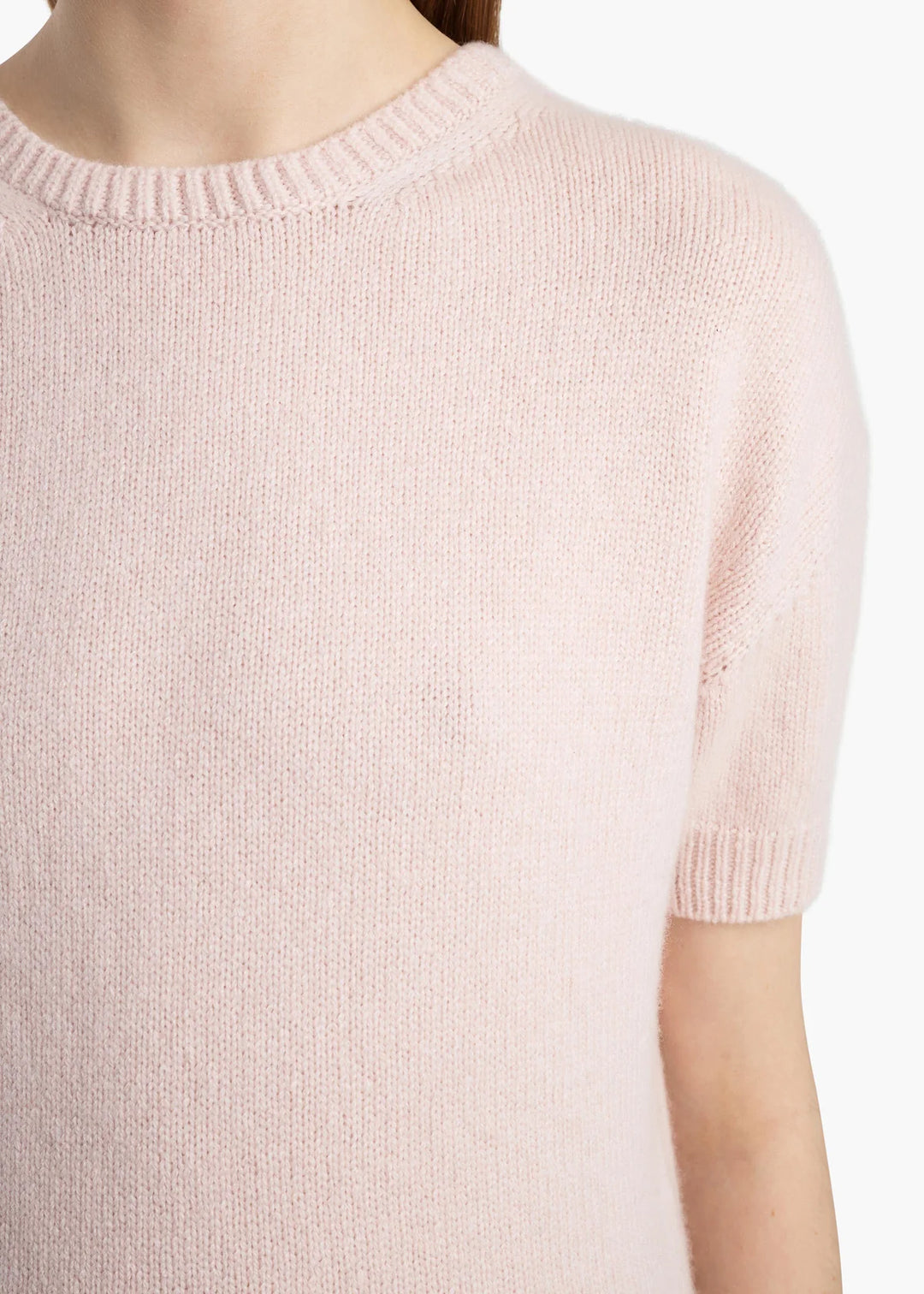 Close-up of a light pink sweater on a white background