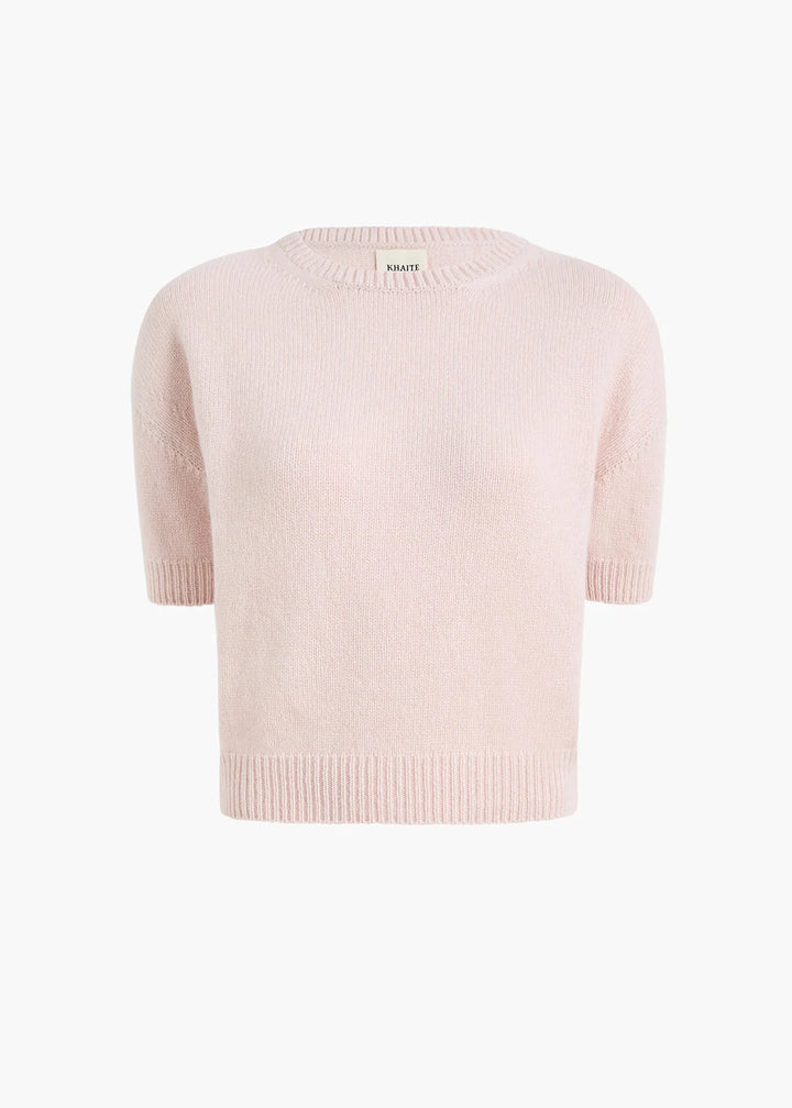 A pale pink knit short-sleeve sweater with a crew neck and ribbed hem, shown against a plain white background.