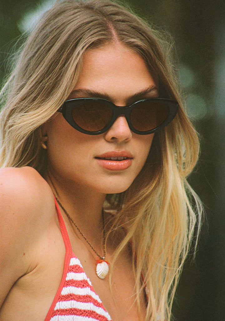 Woman wearing sunglasses with a blurred natural background