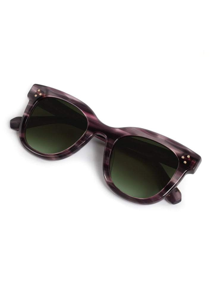 Sunglasses with a purple frame and dark lenses on a white background