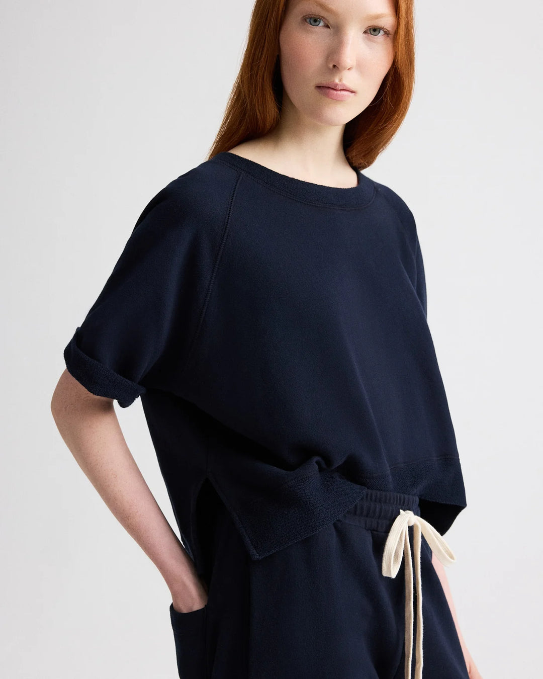 Woman wearing a navy blue dress with a white background