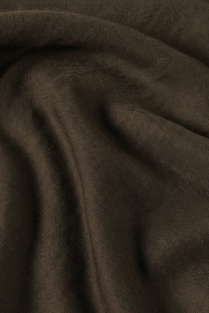 A close-up of draped dark brown fabric with a soft, slightly fuzzy texture.