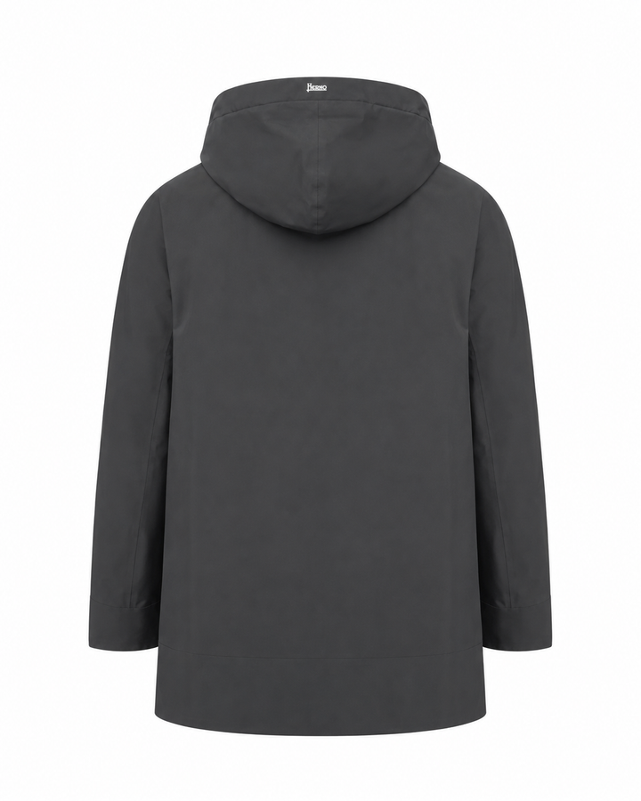 A dark gray hooded jacket shown from the back, featuring a simple, clean silhouette with a small white brand label on the inside of the hood, set against a plain white background.