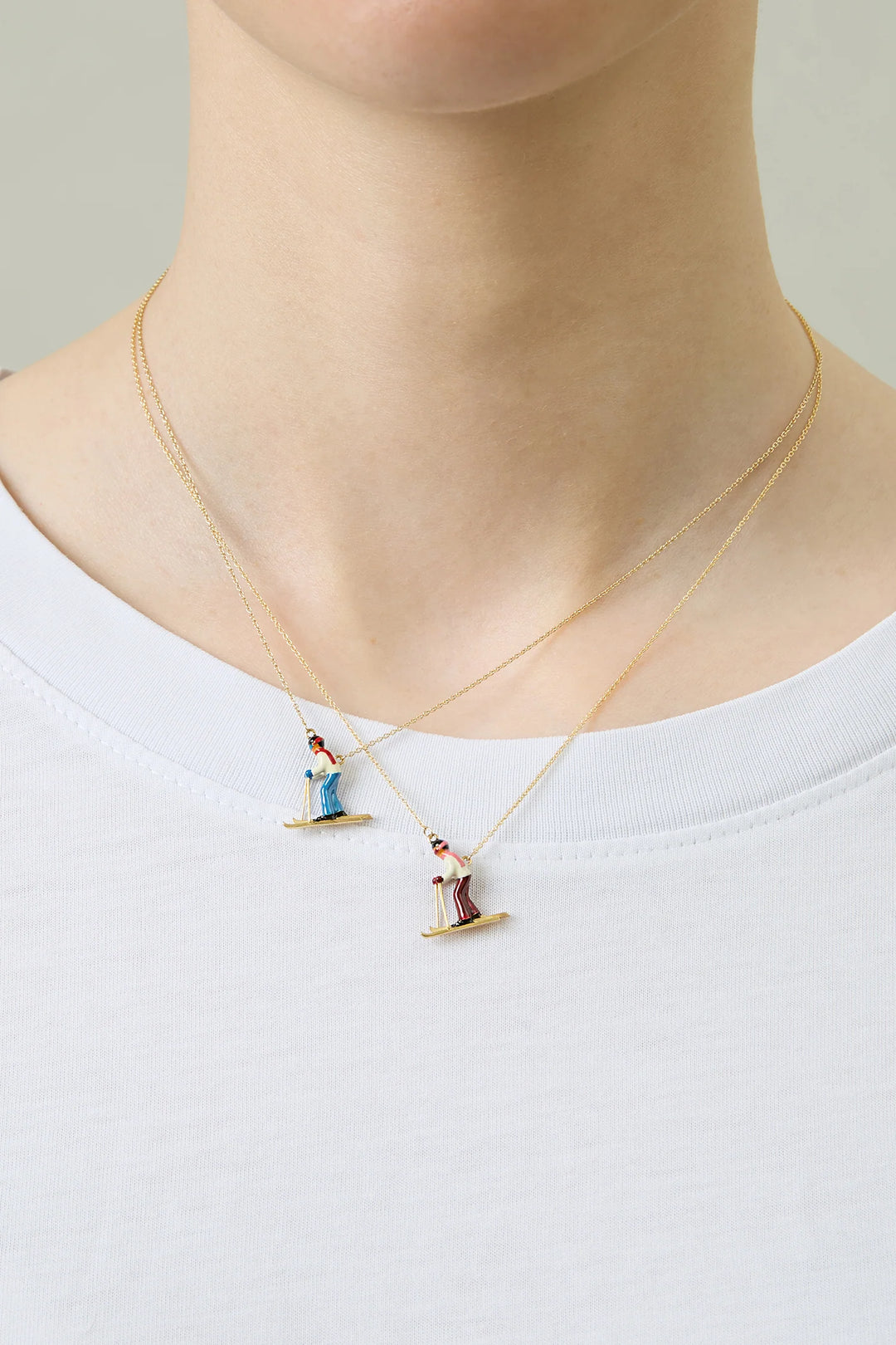 Necklace with small figures on a plain background