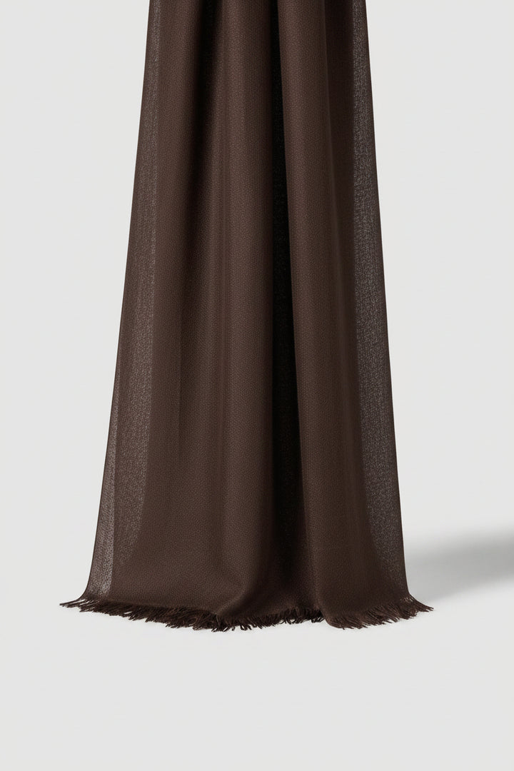 An olive green scarf with fringed edges, draped elegantly against a light gray background.