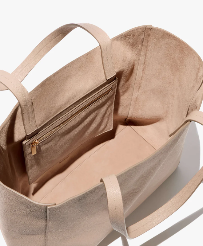 Beige handbag with a gold zipper on a white background