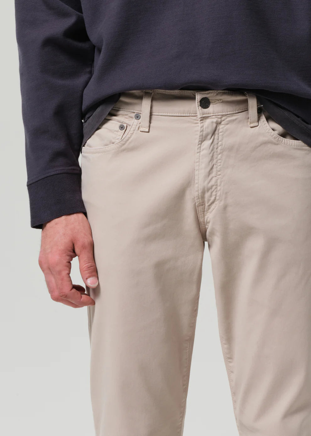 Beige pants worn by a person on a plain background