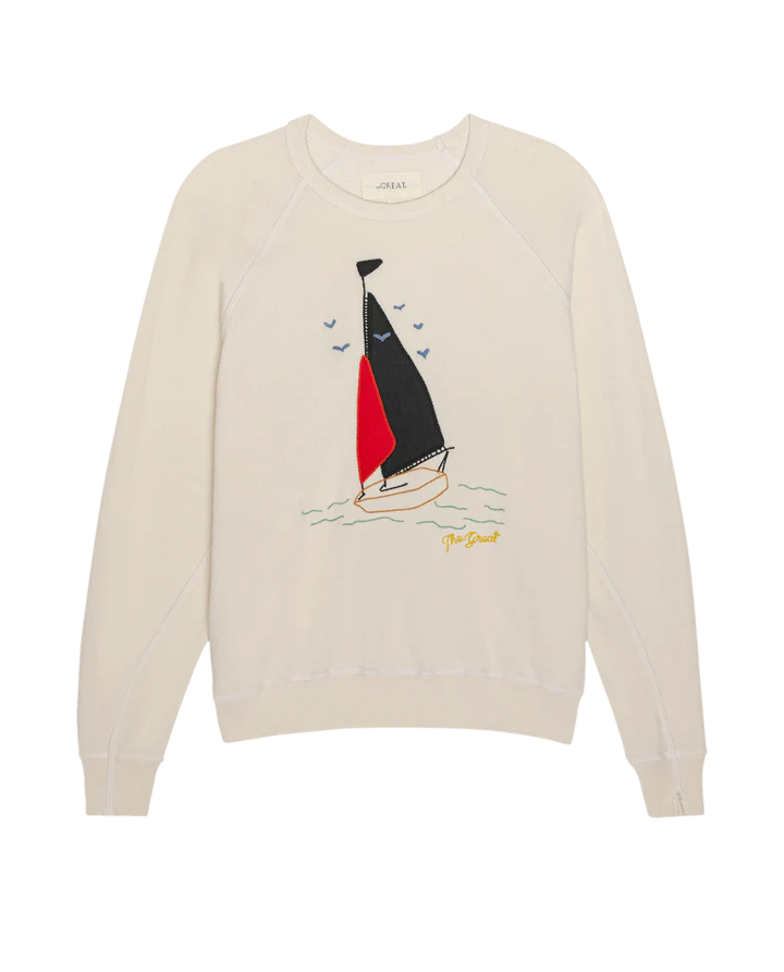 Beige sweater with sailboat design on a white background