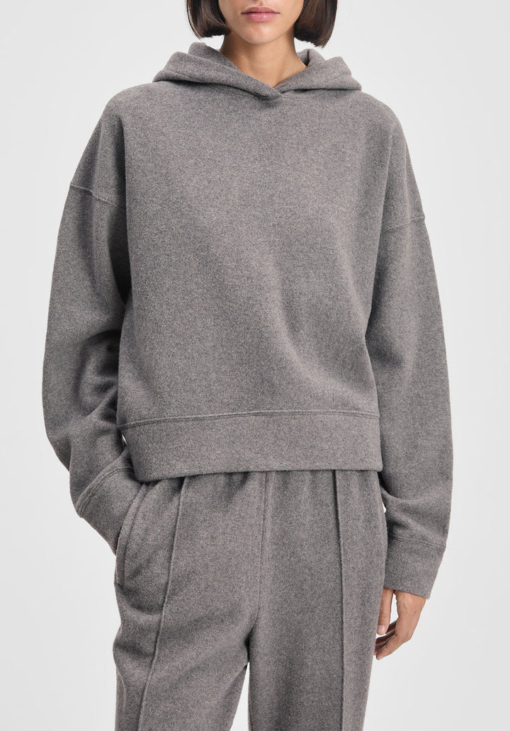 Person wearing a gray hoodie and pants on a white background