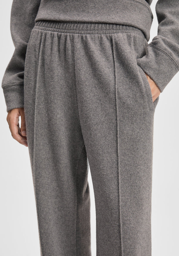 Gray sweatpants worn by a person on a light gray background