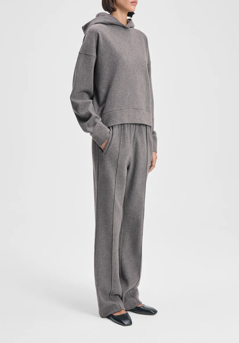 Person wearing a gray hoodie and pants on a white background