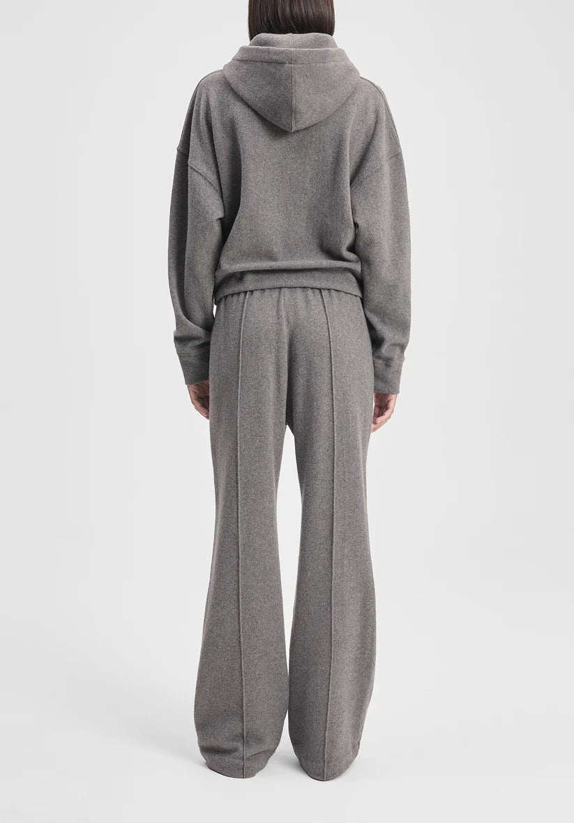 Person wearing a gray tracksuit on a light gray background