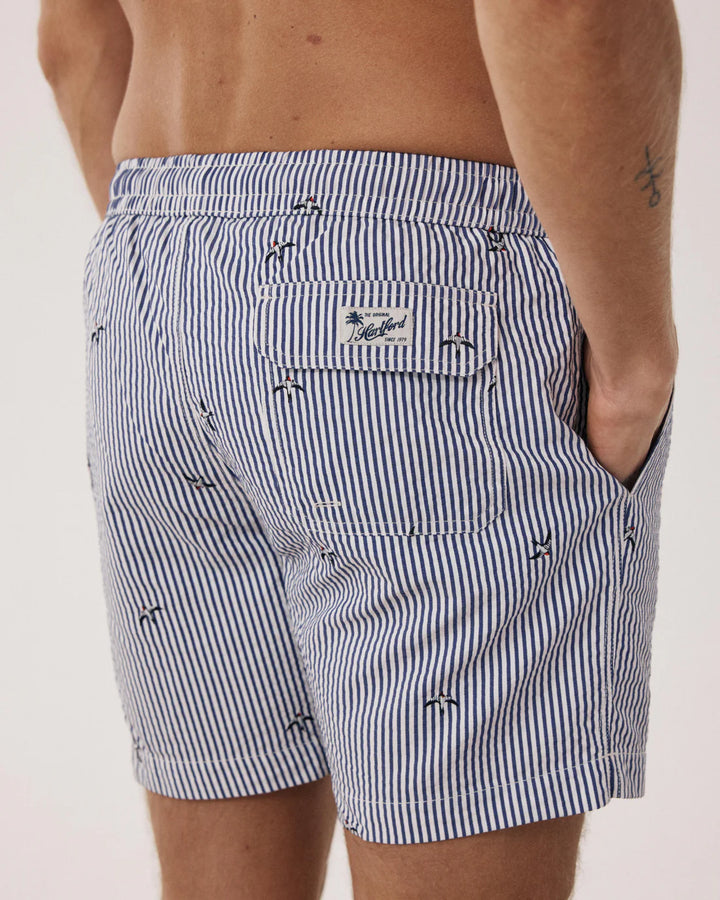 Black and white striped shorts with a brand logo on a plain background