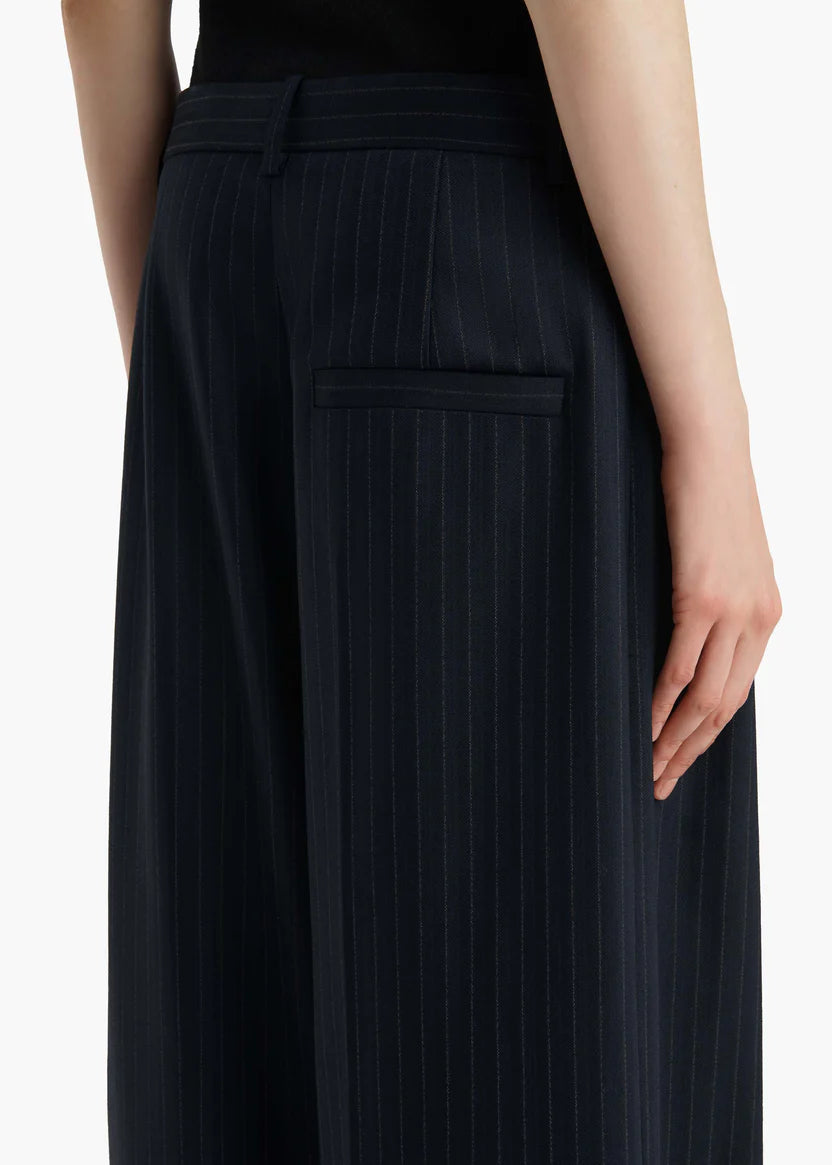 Black pleated skirt worn by a person on a white background