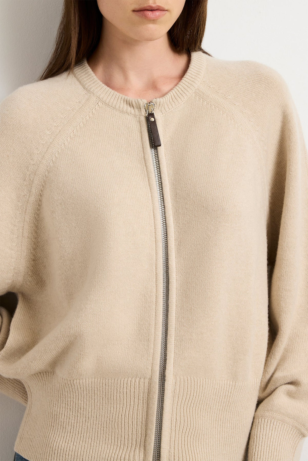 Beige sweater with a zipper on a neutral background