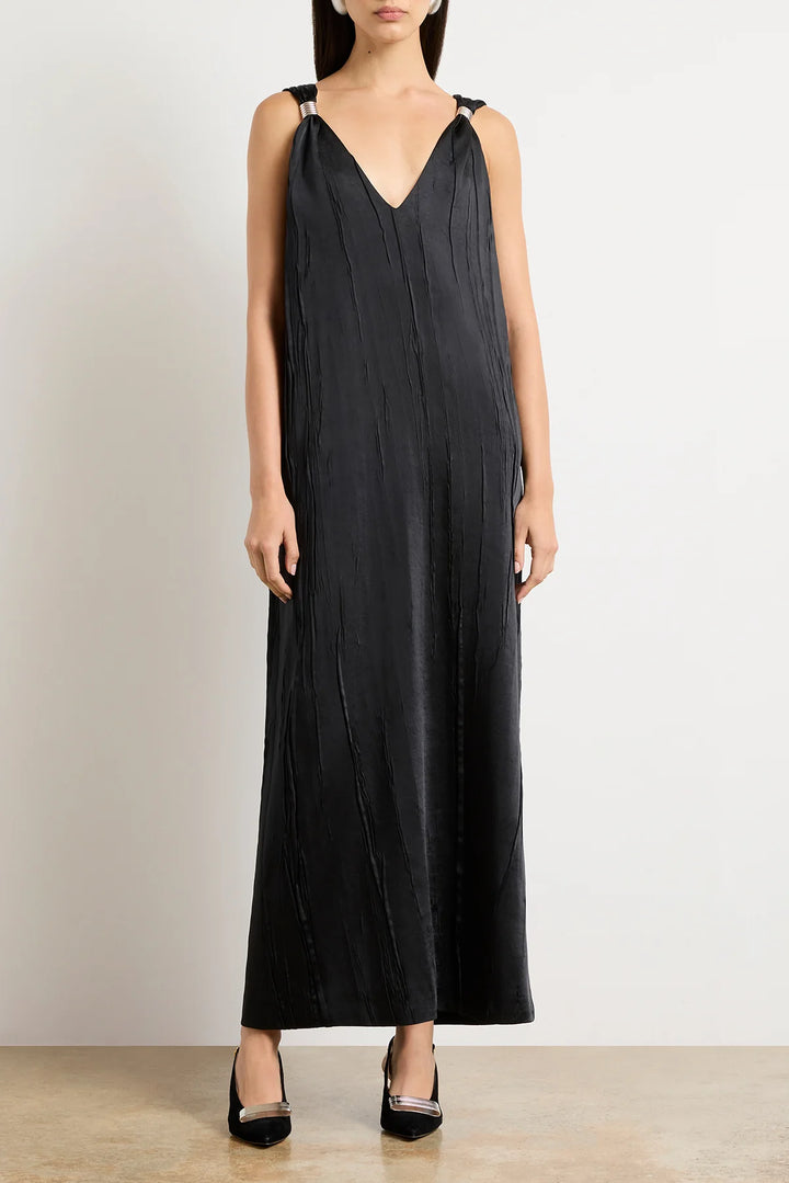 Woman wearing a black sleeveless jumpsuit against a plain background