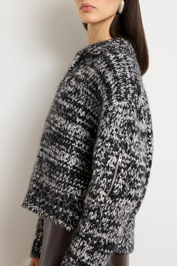 Black and white patterned sweater worn by a person on a plain background