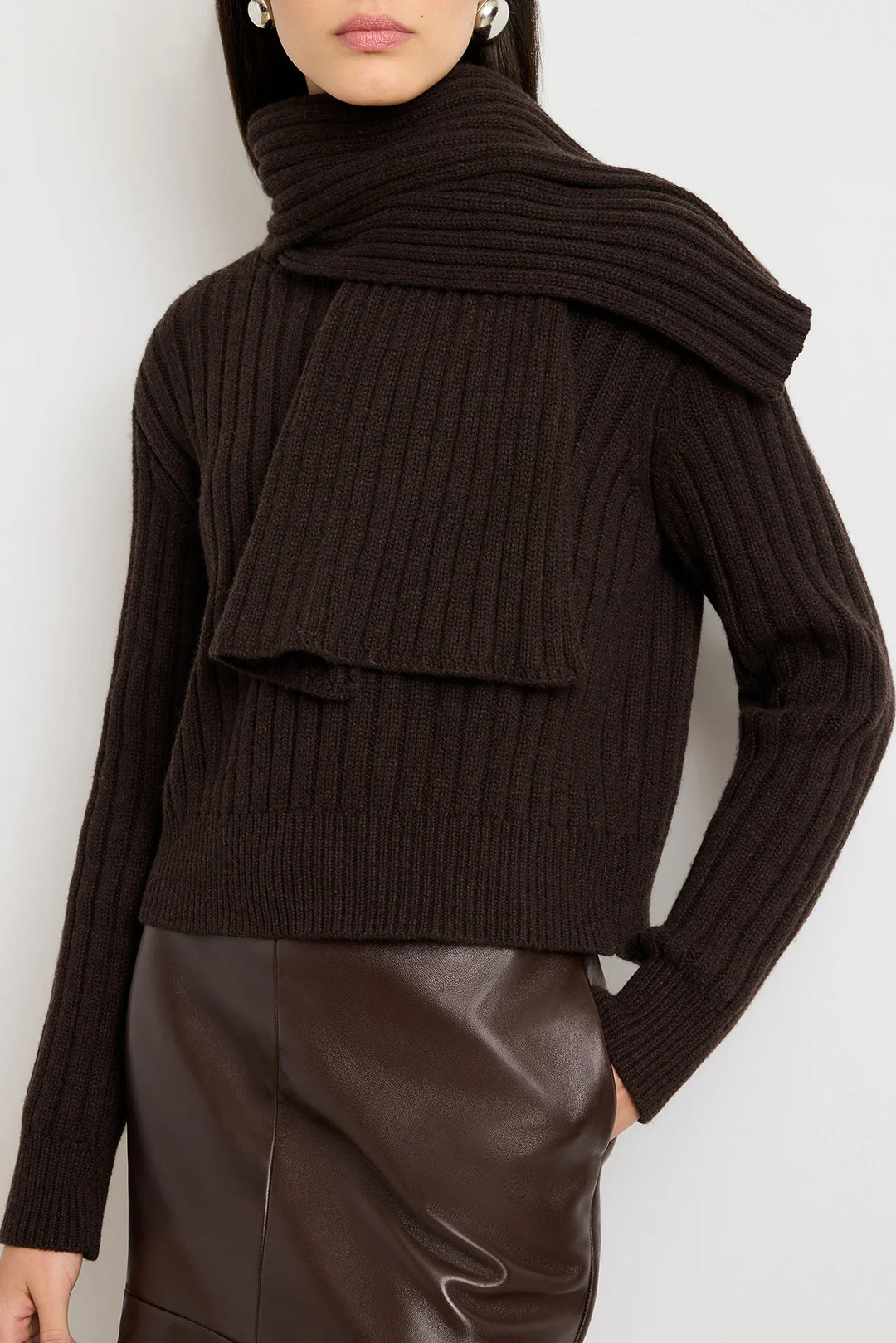 Dark brown ribbed sweater worn by a person on a white background