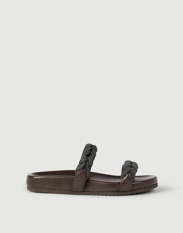 Brown sandal with braided design on a light gray background
