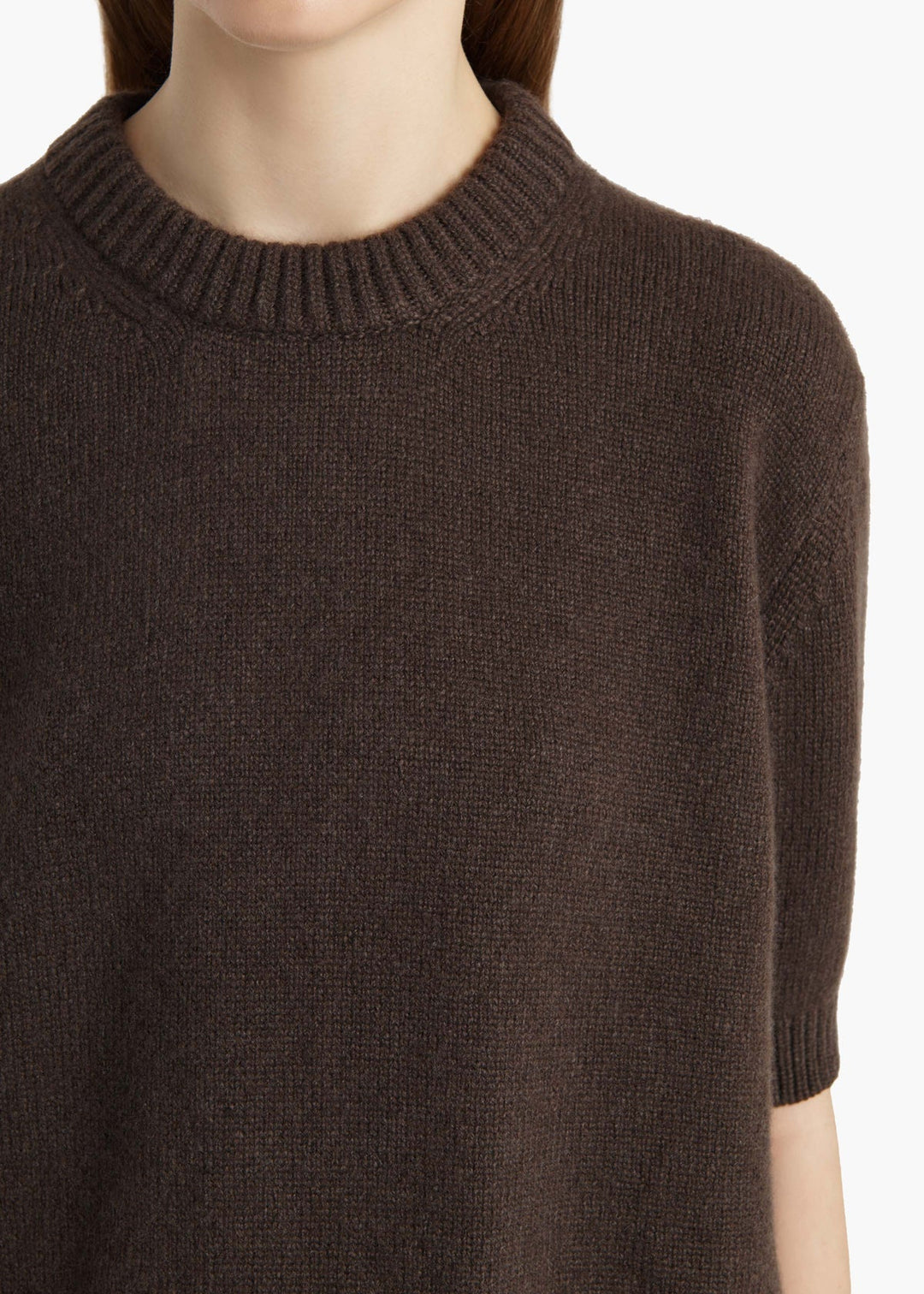 Brown sweater worn by a person on a white background