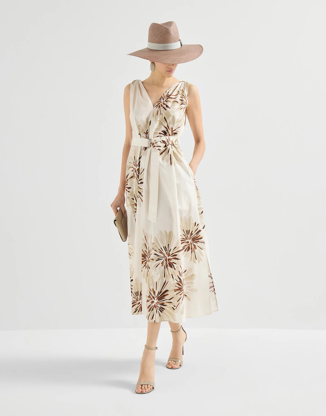 Woman wearing a floral dress and hat on a white background