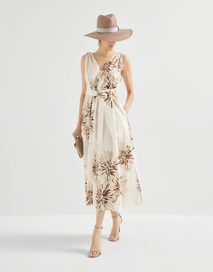 Woman wearing a floral dress and hat on a white background