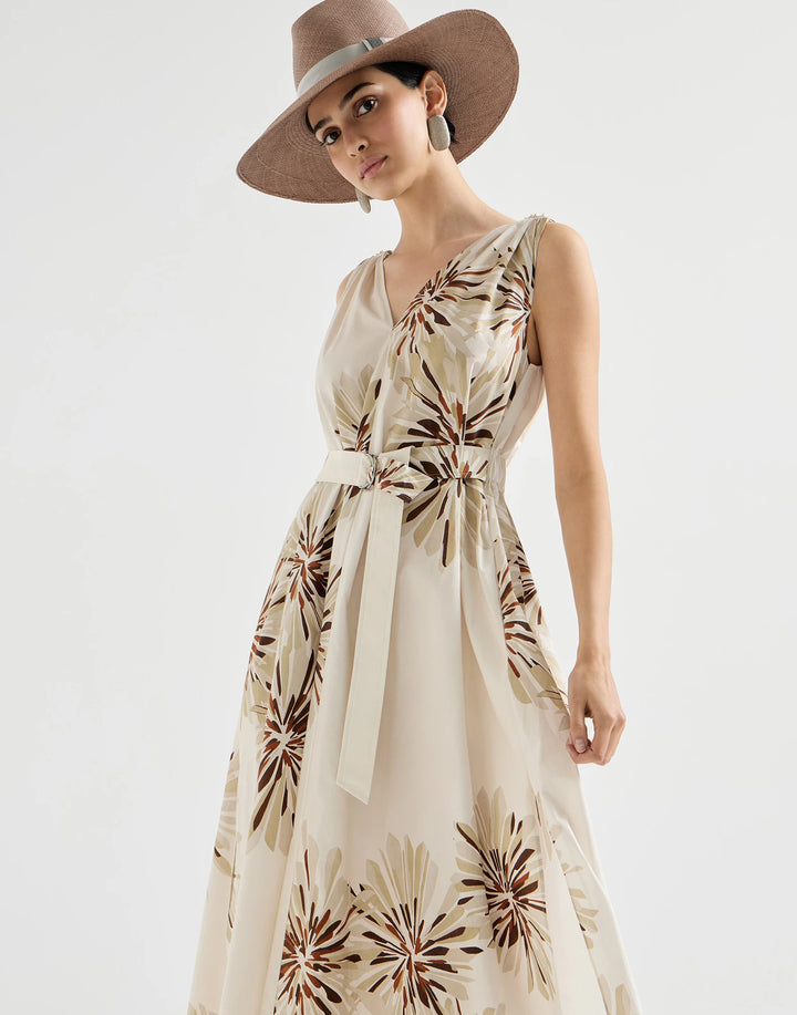 Woman wearing a floral dress and wide-brimmed hat on a white background
