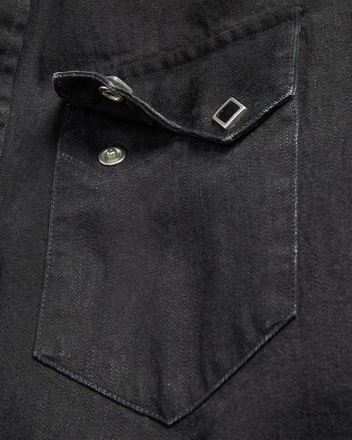 Close-up of a black shirt pocket with a button and flap.