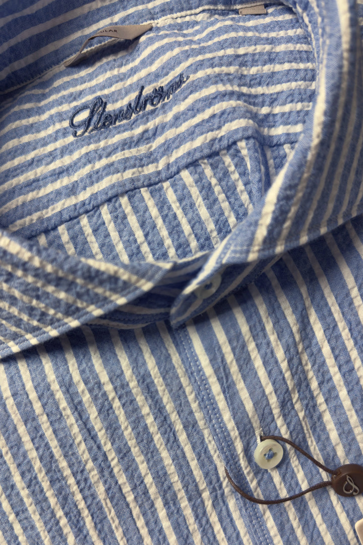 Close-up of a blue and white striped shirt with a brand logo.