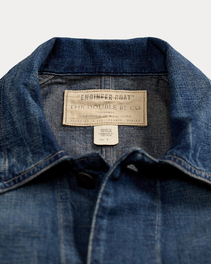 Close-up of a blue denim jacket with brand labels on a white background